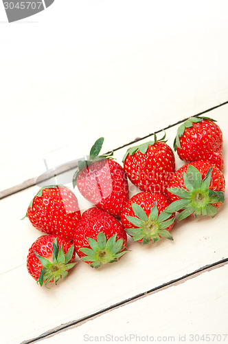 Image of fresh organic strawberry over white wood