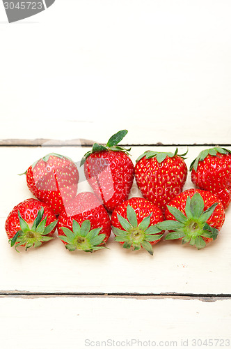 Image of fresh organic strawberry over white wood