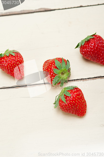 Image of fresh organic strawberry over white wood
