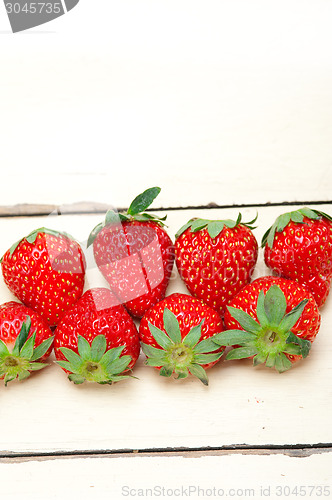 Image of fresh organic strawberry over white wood