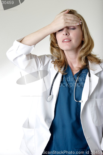 Image of Lady doctor holding head