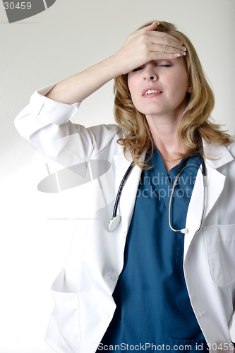 Image of Lady doctor holding head