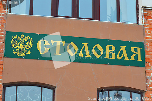 Image of sign with an inscription "Dining room" on a house wall.