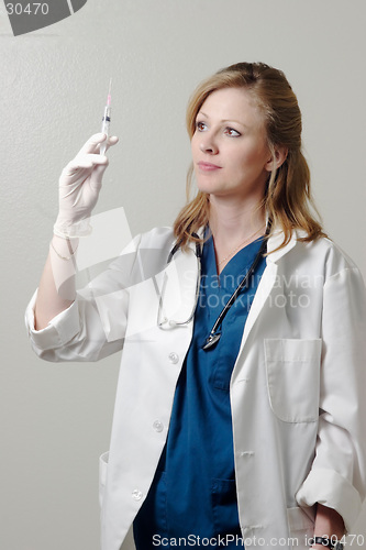 Image of Lady doctor examining syringe