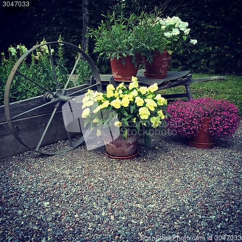 Image of Garden decorated with flowers and old wheel