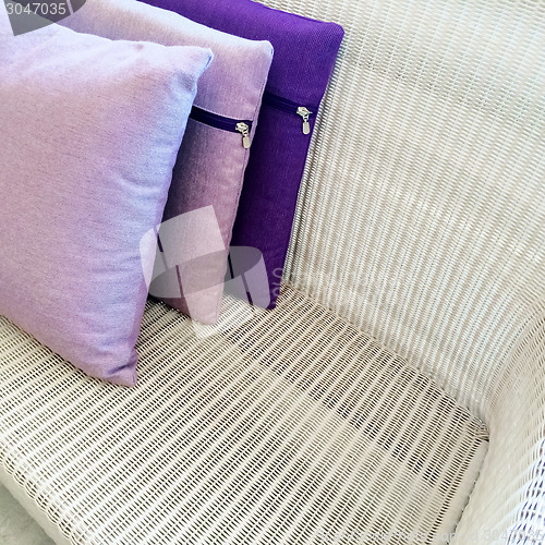 Image of Purple cushions decorating rattan sofa