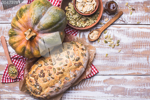 Image of Newly baked bread with pumpkin and seeds wooden table