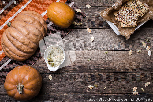 Image of pumpkins with cookies and seeds on wooden table 