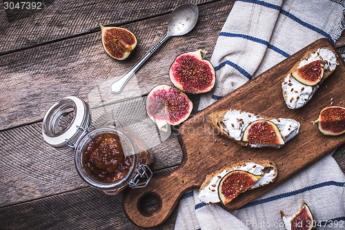 Image of Tasty Bruschetta snacks with figs on napkin in rustic style