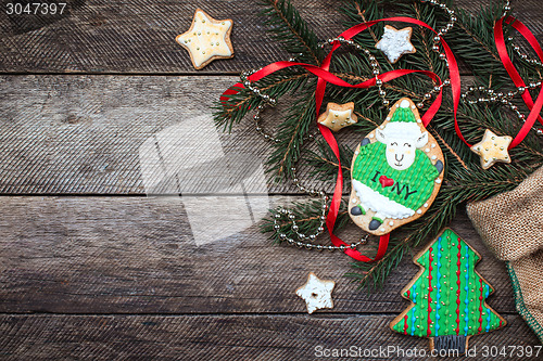 Image of New Year 2015 green sheep cookie and holiday pastry on wood