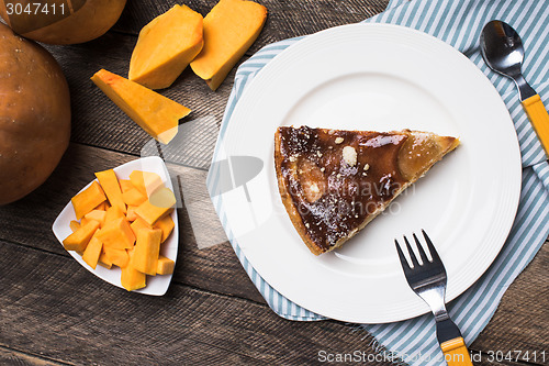 Image of pieces of pumpkin and pie on plate on wood