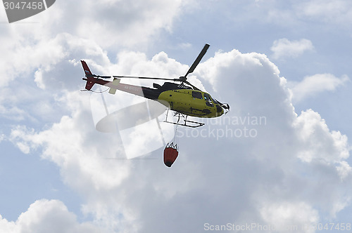 Image of The small yellow helicopter of Utair airline in the sky.