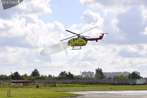 Image of The small yellow helicopter of Utair airline in the sky.