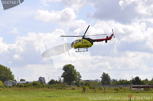 Image of The small yellow helicopter of Utair airline in the sky.