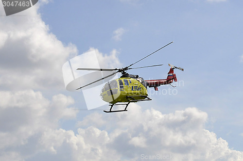 Image of The small yellow helicopter of Utair airline in the sky.