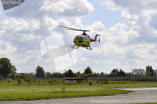 Image of The small yellow helicopter of Utair airline in the sky.