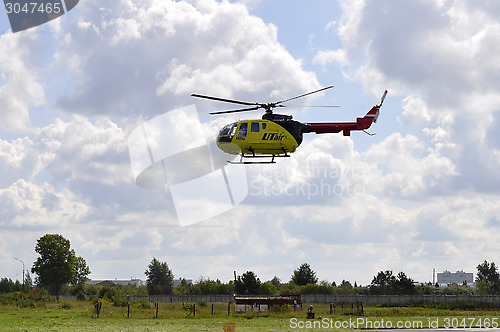 Image of The small yellow helicopter of Utair airline in the sky.