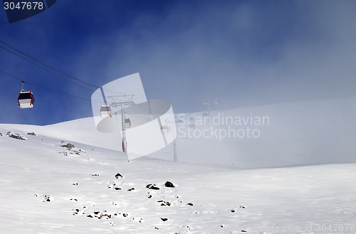 Image of Gondola lifts and ski slope in mist