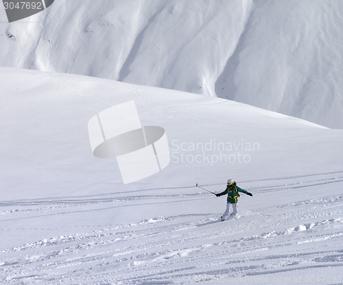 Image of Snowboarder downhill on off piste slope with newly fallen snow