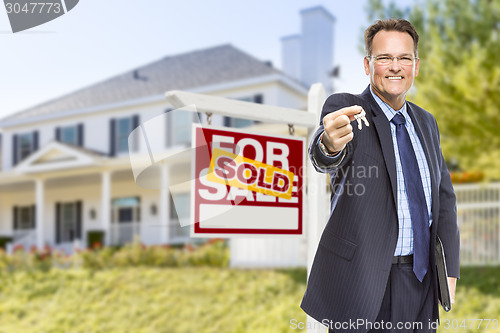 Image of Agent with Keys in Front of Sold Sign and House