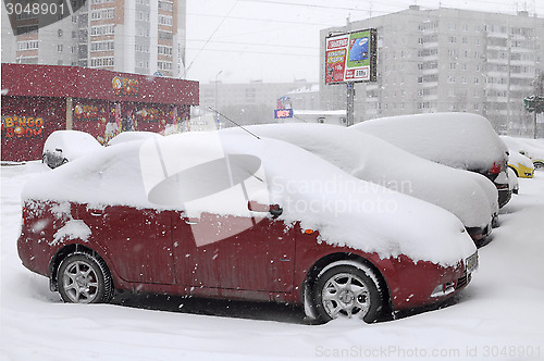 Image of the cars brought by snow are in the yard.