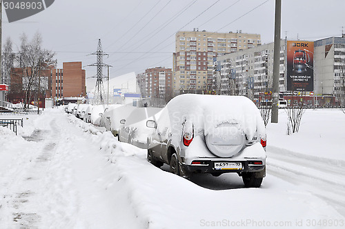 Image of the cars brought by snow are in the yard.