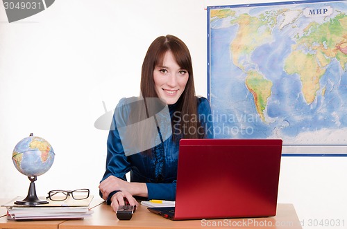 Image of girl behind the desk in office of travel agency