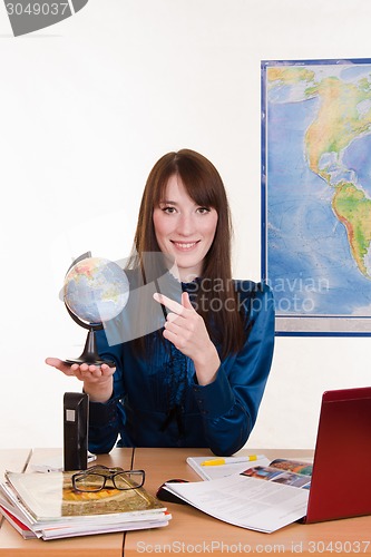 Image of Geography teacher points a finger at the globe