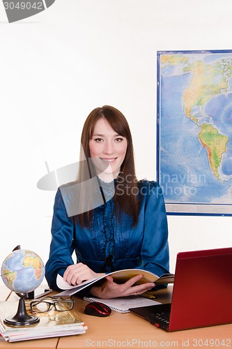 Image of Geography teacher reading a magazine about travel