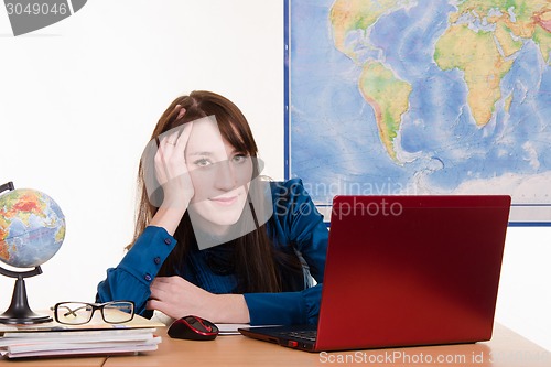 Image of Young teacher of geography has earned for laptop