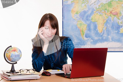 Image of Travel Agent happily looking at a laptop