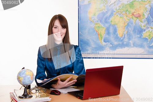 Image of Geography teacher in the classroom with magazine