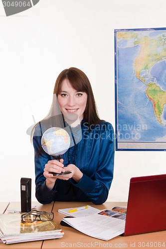 Image of Geography teacher at the table with a globe in his hands