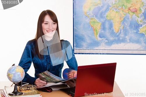 Image of Travel agent flipping through a magazine talking with customers