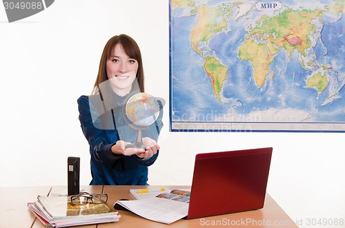 Image of Young employee travel company stretches hands Globe