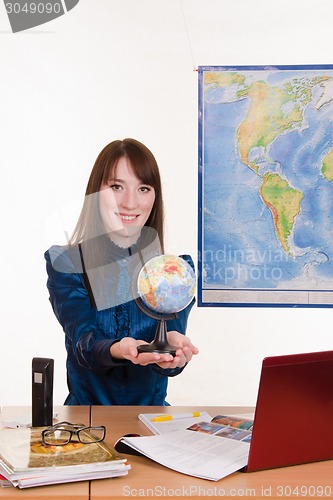 Image of Young employee travel company with a globe in his hand