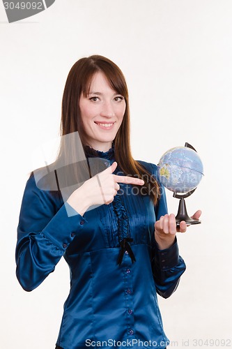 Image of Young girl pointing at globe