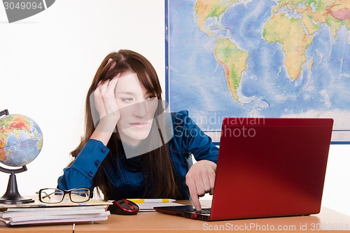 Image of Travel agency manager tired and evil looks in the laptop