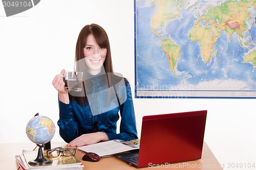 Image of Manager a travel agency with mug of tea in hand