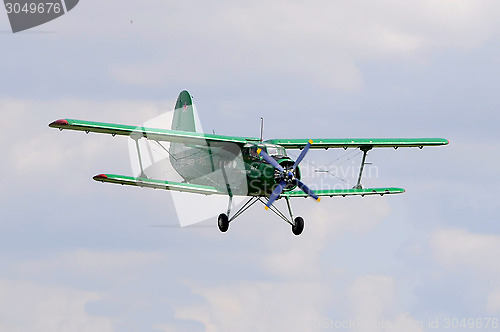 Image of The green An-2 plane in the sky.