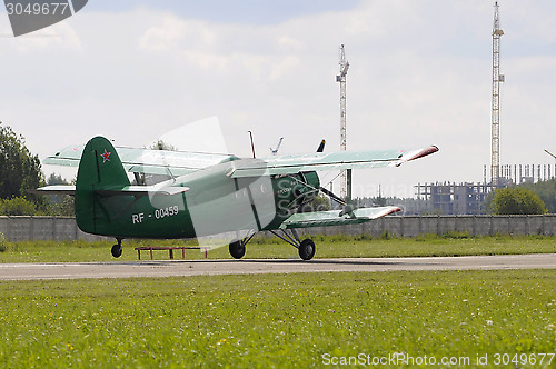 Image of The green An-2 plane on a runway.