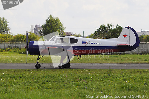 Image of The Yak-18t plane on a runway.