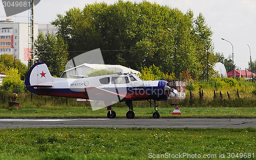 Image of The Yak-18t plane on a runway.