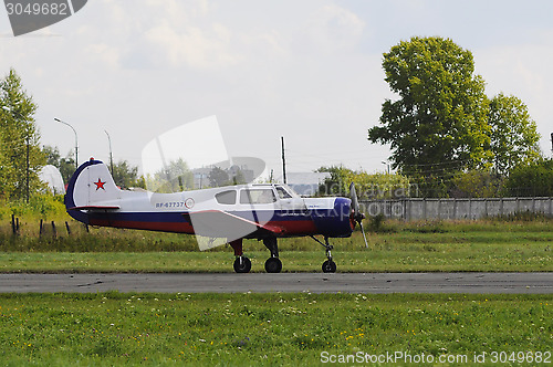 Image of The Yak-18t plane on a runway.