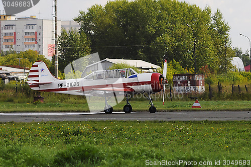 Image of The small white plane on a runway.