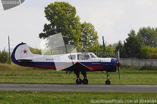 Image of The Yak-18t plane on a runway.