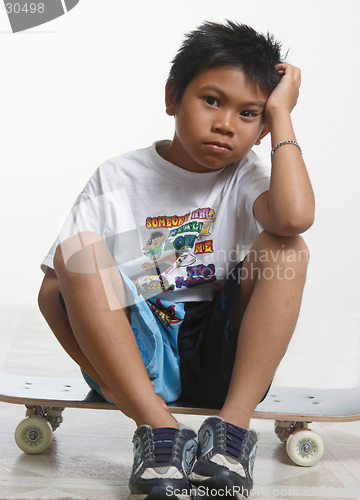 Image of Sad boy sitting on his skateboard