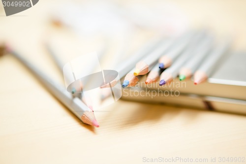 Image of Close up of color pencils over wooden background