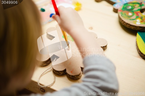 Image of Little female baby painting with colorful paints