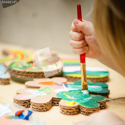 Image of Little female baby painting with colorful paints